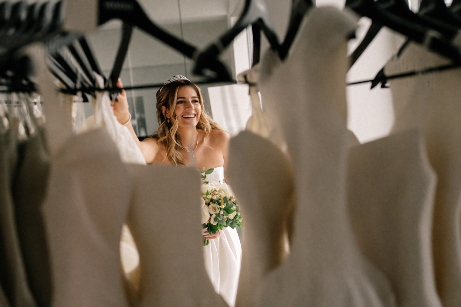 A bride browsing a rack of wedding gowns